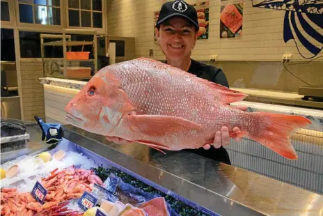  ?? Photo: Amy Lyne ?? TASTY FISH: Central Seafood Market owner Neptina Hunkin with a red emperor fish in the lead-up to the seafood rush before Easter.