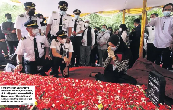  ?? Associated Press ?? Mourners at yesterday’s funeral in Jakarta, Indonesia, of Sriwijaya Air steward Okky Bisma, one of the victims of last weekend’s passenger jet crash in the Java Sea