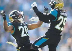  ??  ?? The Jaguars’ Jalen Ramsey, left, and Josh Johnson celebrate after a defensive stop during the first half of Saturday’s game against the Titans. Rob Foldy, Getty Images