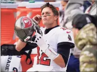  ?? Patrick Semansky / Associated Press ?? Tampa Bay Buccaneers quarterbac­k Tom Brady prepares to put his helmet on while sitting on the sideline in the second half against the Washington Football Team on Nov. 14.