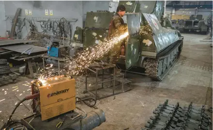  ?? JOHN MOORE/GETTY ?? A mechanic modifies a captured Russian tank for Ukrainian forces to use Monday in eastern Ukraine.