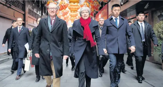  ?? Stefan Rousseau ?? > Prime Minister Theresa May and her husband Philip walk through a market after visiting the Yu Yuan Temple Garden in Shanghai yesterday