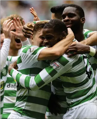  ??  ?? Ntcham is mobbed by his Celtic team-mates after opening the scoring