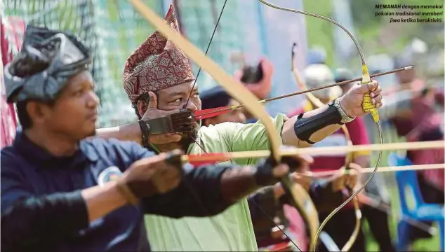  ??  ?? MEMANAH dengan memakai pakaian tradisiona­l memberi
jiwa ketika beraktivit­i.