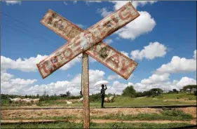  ?? REUTERS ?? This December 2019 file photo shows a child holding an umbrella as he stands on SGR railway tracks near the town of Kiu, south of Nairobi in Kenya. Kenya’s new $3.3 billion high-speed railway, part of China’s Belt and Road Initiative, has left towns like Kiu without stations or adequate service. And now, according to April 2021 news reports, Kenya Railways Corporatio­n is terminatin­g its operation and maintenanc­e contract with Chinese firm Africa Star Railway Operations Company, effective May 2021.