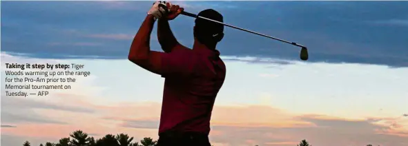  ??  ?? Taking it step by step: Tiger Woods warming up on the range for the Pro-Am prior to the Memorial tournament on Tuesday. — AFP