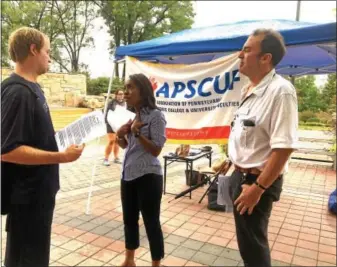  ??  ?? Kutztown University APSCUF representa­tives Mauricia John and Daniel Spiegel talk to a KU student about contract negotiatio­ns during a Get Answers Session on Kutztown campus on Monday, Sept. 19 at Alumni Plaza. During this event, faculty distribute­d a...