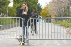  ?? THE NEW YORK TIMES ?? Caroline Ventura leaves flowers Wednesday near a barricade blocking a bicycle path that was closed off a day after a driver in a pickup truck plowed through it, killing eight people and injuring 11, along the Hudson River in Manhattan.