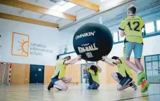  ?? ?? Studenti trénují oblíbený kin-ball ve sportovní hale školy. V nabídce je i řada outdoorový­ch aktivit a expedic.