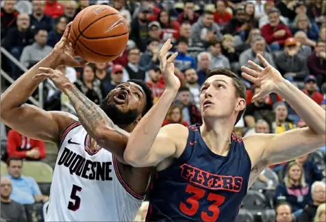  ?? Peter Diana/Post-Gazette ?? Dayton’s Ryan Mikesell, right, fouls Duquesne’s Marcus Weathers Wednesday night.