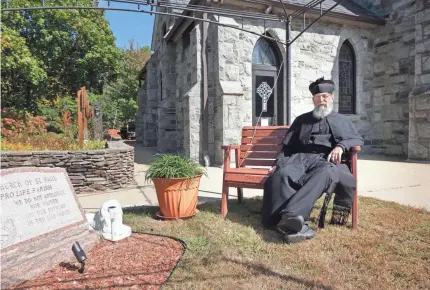  ?? PHOTOS BY SANDOR BODO/USA TODAY NETWORK ?? Father D. Timothy O’Mara sits at St. Paul's Church, bisected by the state line.