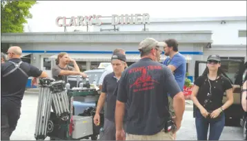  ?? ANN DAVIDSON ?? The stunt team for the production of “The Truth About The Harry Quebert Affair” wait for their cues in front of the diner specially built in the centre of Frelishsbu­rg as part of the set.