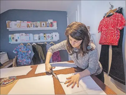  ?? CP PHOTO ?? Erica Penton cuts out what will be sleeve for a sweater she was making, in the workspace at her home in Halifax. Except for her socks, she has made all of her own clothing for the last several years.