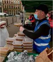  ??  ?? Below Right: Handing out food at a Kindness stall