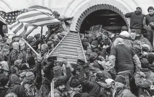  ?? Lev Radin / Tribune News Service ?? Insurrecti­onists clashing with police use a ladder to try to force entry into the Capitol on Jan. 6, 2021, in Washington, D.C. Rioters attempted to overthrow the results of the 2020 election.