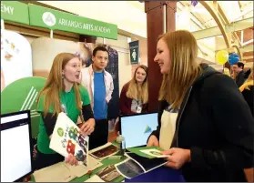  ?? NWA Democrat-Gazette/FLIP PUTTHOFF ?? Rachel Carpenter (left), a music teacher at Arkansas Arts Academy in Rogers, shares informatio­n Saturday about the school at the annual Northwest Arkansas School Choice Festival. Representa­tives from dozens of public and private schools offered...