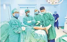  ?? ?? The medical team involved in the surgery to replace a diseased heel bone with a 3D moulded replacemen­t for the calcaneal bone at the Queen Elizabeth Hospital.