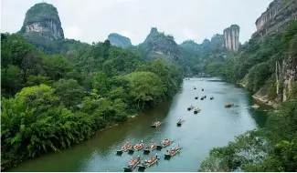  ?? ?? Tourists on bamboo rafts tour the Jiuqu river at a Wuyi mountain scenic area in southeast China's Fujian Province on 3 October 2023.