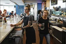  ?? RODOLFO GONZALEZ / FOR AMERICAN-STATESMAN ?? Bartender Brittani Foret (left), 27, and Shannan Cole, 23, assistant team lead, work Tuesday at Kerbey Lane Cafe’s South Lamar location. Foret will transfer to the firm’s new Mueller site when it opens in November.