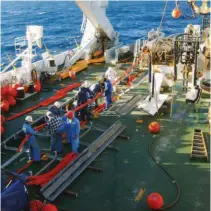  ??  ?? Above: The crew aboard a cable-laying ship feeding a subsea cable into the burial plough.