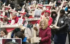  ?? | ASHLEE REZIN/ SUN- TIMES ?? A cross bearing the name and photo of John Hosey Jr., one of the 16 people killed in Beat 1133 last year, was carried down Michigan Avenue in a march organized by the Rev. Michael Pfleger at the end of 2016.