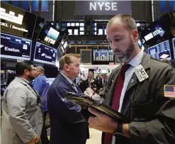  ?? —AP ?? NEW YORK: Trader Thomas Cicciari (right) works on the floor of the New York Stock Exchange yesterday.