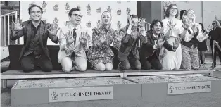  ?? PHOTO BY WILLY SANJUAN/INVISION/AP ?? Johnny Galecki, from left, Jim Parsons, Kaley Cuoco, Simon Helberg, Kunal Nayyar, Mayim Bialik and Melissa Rauch, members of the cast of the TV series “The Big Bang Theory,” show their hands after placing them in cement during a hand and footprint ceremony at the TCL Chinese Theatre on Wednesday in Los Angeles.