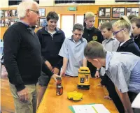  ??  ?? Gore suilder Neter Goodger shows year 10 pupils from Gore High Qchool some of the hightech equipment used in the trade during a Qouthland Youth Futures employer talk earlier this year.