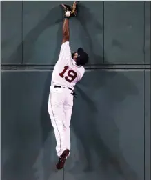  ?? The Associated Press ?? Boston Red Sox centre fielder Jackie Bradley Jr. leaps against the wall but can’t make the play on a double by Toronto Blue Jays’ Ryan Goins during the ninth inning at Fenway Park in Boston on Wednesday.