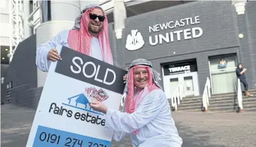  ?? AFP ?? Newcastle supporters pose outside St James’ Park after the sale of the club to a Saudi Arabia-led consortium.