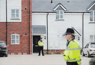  ?? MATT DUNHAM THE ASSOCIATED PRESS ?? British police officers stand outside a residentia­l property in Amesbury, England. Police have declared a “major incident” after two people were exposed to an unknown substance in the town.