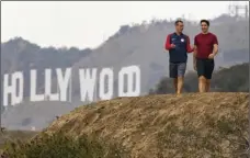  ?? PHOTO/DAMIAN DOVARGANES ?? Los Angeles Mayor Eric Garcetti (left) and Canadian Prime Minister Justin Trudeau take a hike in the Hollywood hills after a news conference at the Griffith Observator­y on Saturday in Los Angeles. AP