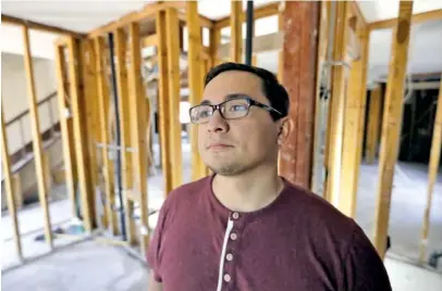  ?? THE ASSOCIATED PRESS ?? Jacob Lerma poses Monday inside his home, which was damaged by floodwater­s from Hurricane Harvey in Friendswoo­d, Texas. Five months after Harvey damaged thousands of houses in Texas, financial difficulti­es many homeowners still face as they work to...