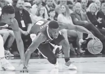  ?? Rick Bowmer, The Associated Press ?? Nuggets guard Emmanuel Mudiay maintains his dribble as Utah Jazz guard Donovan Mitchell defends during the first half Wednesday night in Salt Lake City.