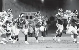  ?? Gina Ferazzi Los Angeles Times ?? C.J. ANDERSON of the Rams dashes through a big hole in the fourth quarter for some of his 123 yards rushing against Dallas. He scored two touchdowns.