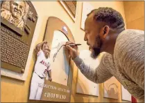  ??  ?? Milo Stewart Jr. / National Baseball Hall of Fame and Museum via AP
Vladimir Guerrero signs the spot where his Baseball Hall of Fame plaque will hang during a visit to the hall Thursday in Cooperstow­n, N.Y.