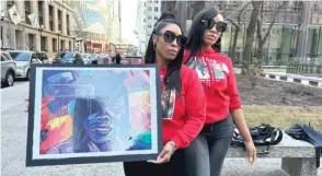  ?? EMMANUEL CAMARILLO/ SUN-TIMES ?? Oretha Miller and Robbin Calhoun hold a painting of Cheretha Morrison by artist Damon Lamar Reed outside the Daley Center on Sunday.