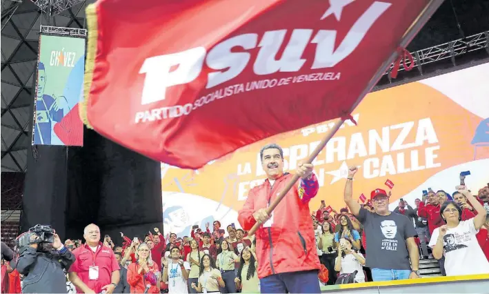  ?? AFP ?? Proclamaci­ón. El líder venezolano, Nicolás Maduro en el acto partidario. Atrás, a su derecha, Diosdado Cabello y la primera dama Cilia Flores. Al otro lado la vice Delcy Rodríguez.