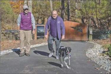  ?? (Bucks County Courier Times/Nancy Rokos) ?? Tim Weaver (left) and partner Phil Gutis take a walk around their property in New Hope, Pa., with their dog, Charly. Gutis was diagnosed with Alzheimer’s five years ago and is taking part in an experiment­al trial. “I don’t remember what caused me to be concerned,” he said. “Something wasn’t right.”
