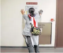  ?? REUTERS ?? A protester looks at a floor plan of a building during a search for fellow protesters who might be hiding, at the Hong Kong Polytechni­c University (Polyu) in Hong Kong on Friday.