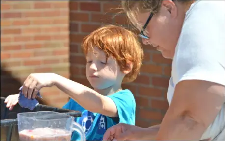  ?? EL File Photo ?? Henry Adams works with Melissa Jordan to gather paper pulp to make a new sheet of paper at Arts in the Parks, hosted by Arts Place Auglaize/Mercer Center on July 17, 2018. The center hopes to return to a full-scale Arts in the Parks event this summer after 2020’s event was different because of the pandemic.