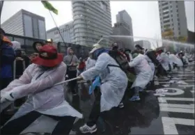  ?? AHN YOUNG-JOON — THE ASSOCIATED PRESS ?? South Korean protesters pull a wire to remove a police bus as they try to march to the Presidenti­al House after a rally against government policy in Seoul, South Korea, Saturday. Police fired tear gas and water cannons Saturday as they clashed with...