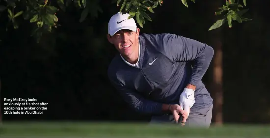  ??  ?? Rory McIlroy looks anxiously at his shot after escaping a bunker on the 10th hole in Abu Dhabi