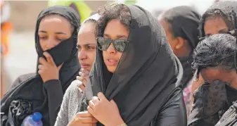  ?? JEMAL COUNTESS/GETTY IMAGES ?? Mourners, believed to be Ethiopian Airlines cabin crew members, arrive to pay respects at the crash site of Ethiopian Airlines Flight ET302 on Thursday in Ejere, Ethiopia.