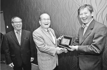  ??  ?? Loh (right) presents a memento to Uggah. Also seen is Department of Veterinary Services Sarawak director Dr Adrian Susin Ambud.