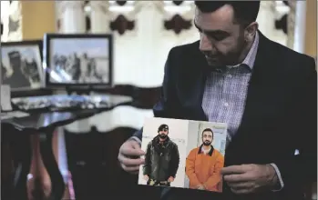  ?? AP PHOTO/DAVID J. PHILLIP ?? Sami-ullah Safi holds photograph­s of his brother, Abdul Wasi Safi, as he talks about his brother’s journey to the U.S. during an interview on Jan. 18, in Houston.