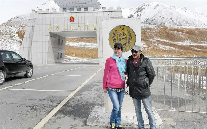  ??  ?? A Chinese woman (left) poses for a photograph with a Pakistani man at the Pakistan-China Khunjerab Pass, the world’s highest paved border crossing at 4,600 meters above sea level. —AFP