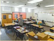  ??  ?? 公校教師工作辛苦，圖為內華達州一名小學­教師在上課前，進教室準備。 （美聯社)