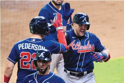  ?? ERIC GAY/ASSOCIATED PRESS ?? The Atlanta Braves’ Adam Duvall, right, celebrates his two-run home run with teammate Joc Pederson during the third inning of Game 1 of the World Series against the Houston Astros on Tuesday in Houston.