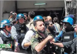  ?? UNITED MEDIA OFFICE OF ARBEEN/ THE ASSOCIATED PRESS ?? Members of a U.N. team with blue helmets walk with Syrian rebels in Zamalka, Syria, on Wednesday. U.N. chemical weapons experts headed to a Damascus suburb for a new tour of areas that the United States has said were attacked by chemical weapons.